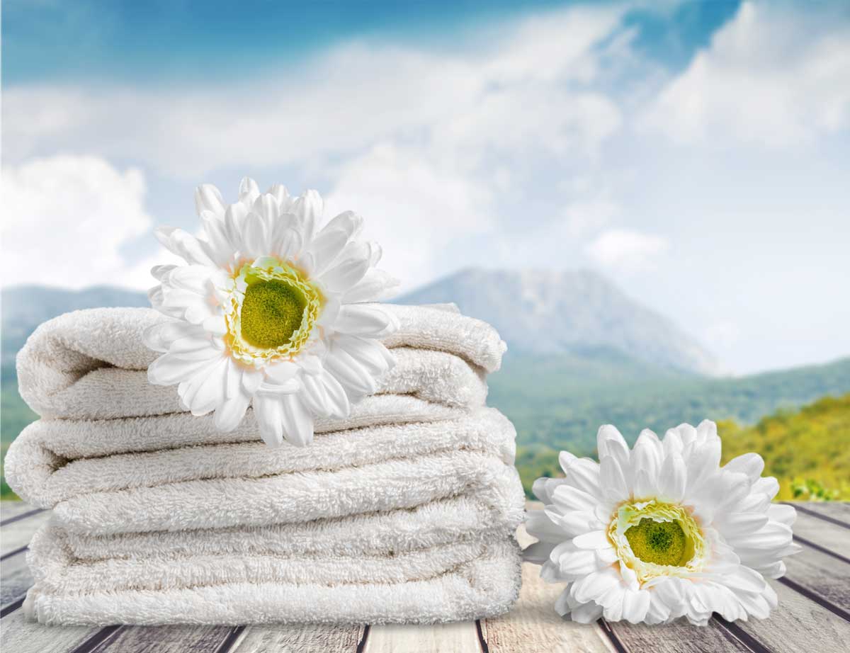 Pile of fluffy towels and flower on