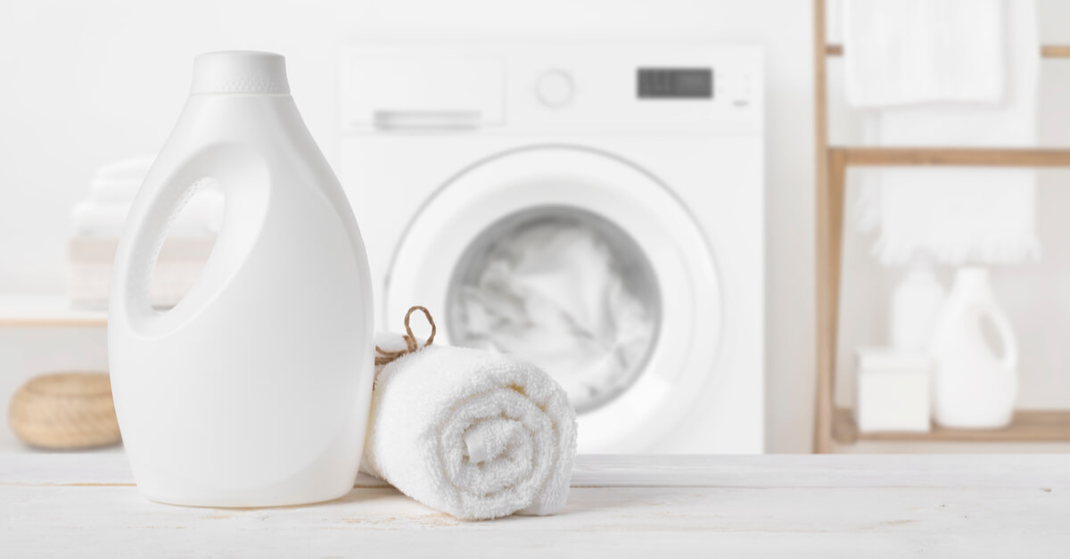 Plain detergent bottle on wood over defocused laundry room interior eco laundry concept